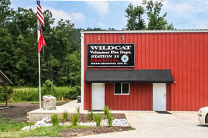 red steel metal buildings, fire station, large doors, flag, window and walk doors with awning
