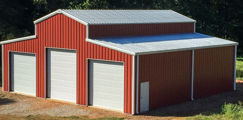 Red barn steel building with white doors and raised center