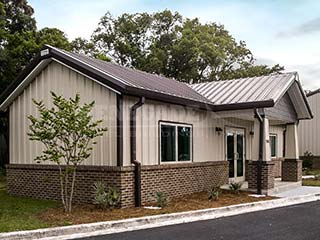 Tan Renegade steel building with brown trim and roof and brick wainscot