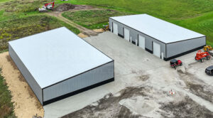 60x104x18 single slope steel building with large doors, gray walls with black trim and wainscot.