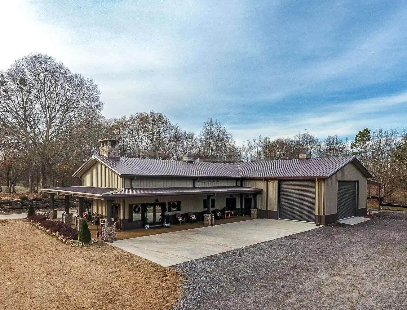Tan and brown Barndominium with 32x50x16 main house with wrap around porch and 40x100x16 shop area
