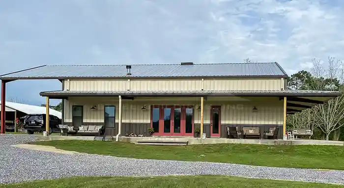 Renegade Steel Building used as a home. Tan walls with burnished slate wainscot, open bay and wrap around porch.