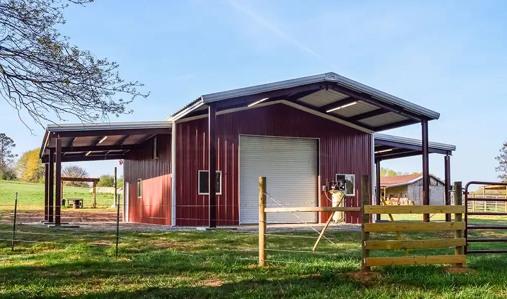 Renegde farm bulding with red walls and white door, also has lean to on each side