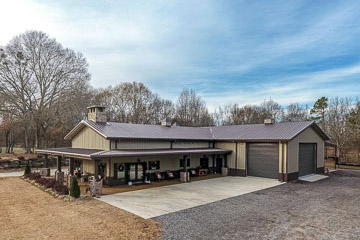 Steel Building Barndominium with tan walls and brown roof. Also has wrap around porch.